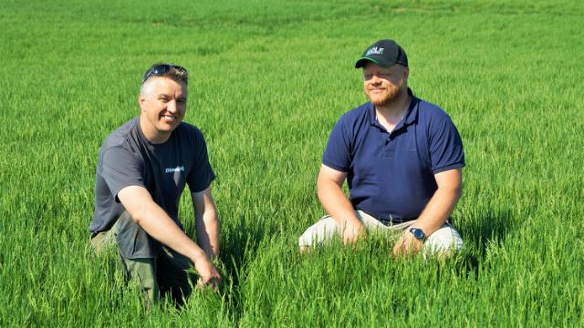 Two men sitting on grass field
